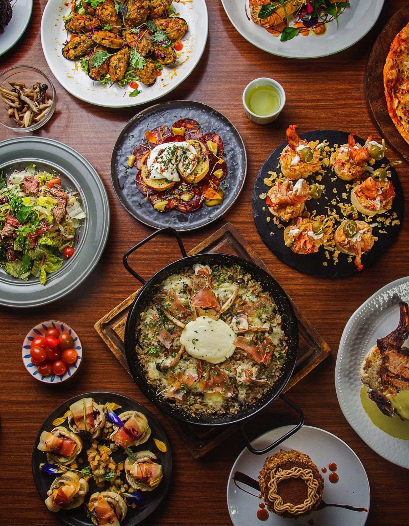 Delgado 112 signature dishes spread — paella, pasta, seafood, and more